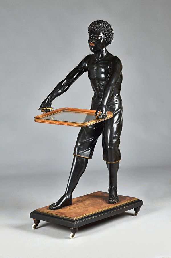 A 19th century Continental carved and poly chrome painted dumb waiter, in the form of a standing Nubian man holding a serving tray, 145cm high. Proven