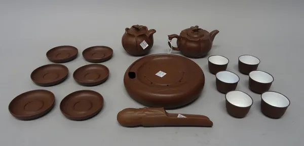 A Chinese Yixing stoneware tea service, 20th century, including a lotus moulded lidded teapot and jug with butterfly knops, a teapot stand, six teabow