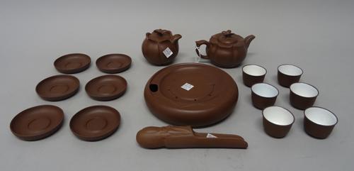 A Chinese Yixing stoneware tea service, 20th century, including a lotus moulded lidded teapot and jug with butterfly knops, a teapot stand, six teabow
