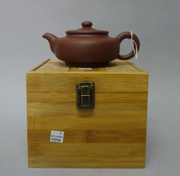 A Chinese Yixing stoneware teapot and cover, 20th century, of compressed globular form with button knop, signed, 7.75cm. high, boxed, (3).