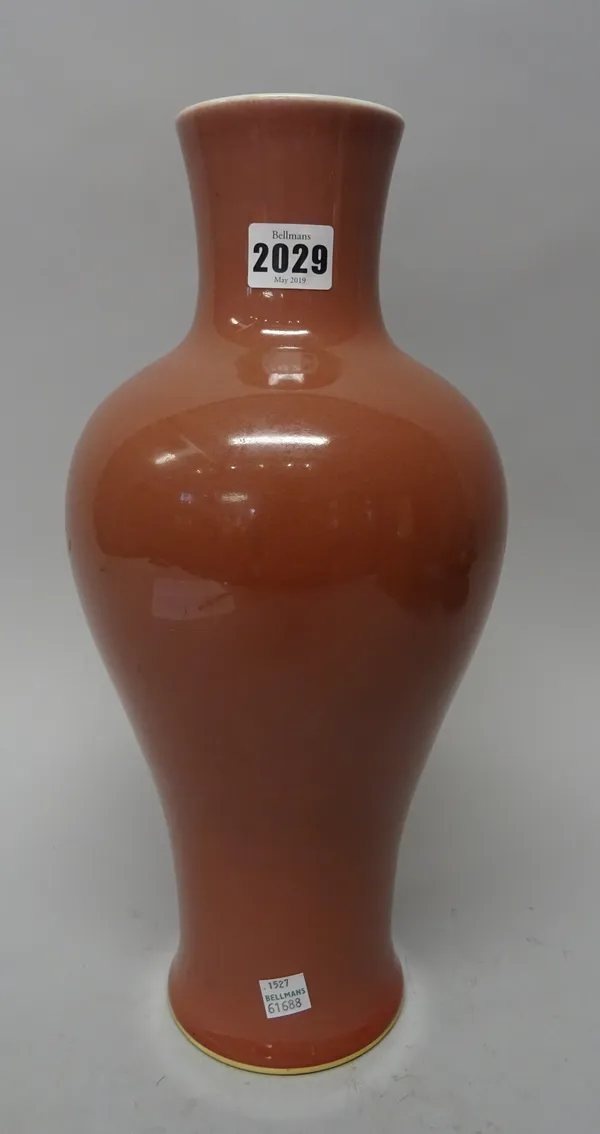 A tall Chinese `peachbloom' glazed  vase, blue painted Kangxi six character mark but later, of slender baluster form , covered in a pinkish red glaze,