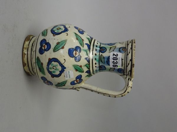 An Iznik pottery jug, Ottoman Anatolia, first half 17th century, of bulbous form with waisted neck and scroll handle, painted with stylised pomegranat