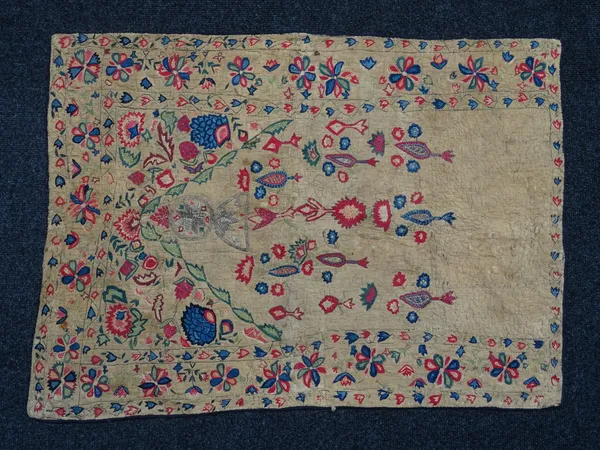 An embroidered prayer mat, Persia, early 19th century, silk embroidered quilted cotton with metal thread, of rectangular form with central floral mihr