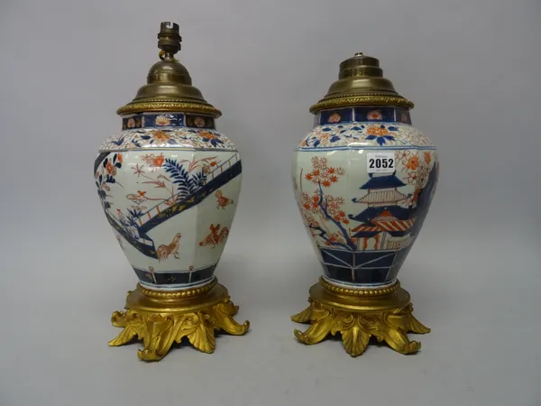 A pair of Japanese Imari ormolu mounted vases, Edo period, of octagonal baluster form, each painted with cockerels and hens in a fenced garden beside