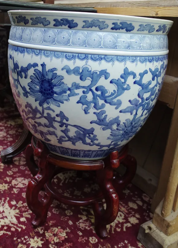 A pair of large Chinese blue and white porcelain jardinieres, each decorated with a broad band of lotus flowers, 44cm. high, 50cm. diameter, wood stan