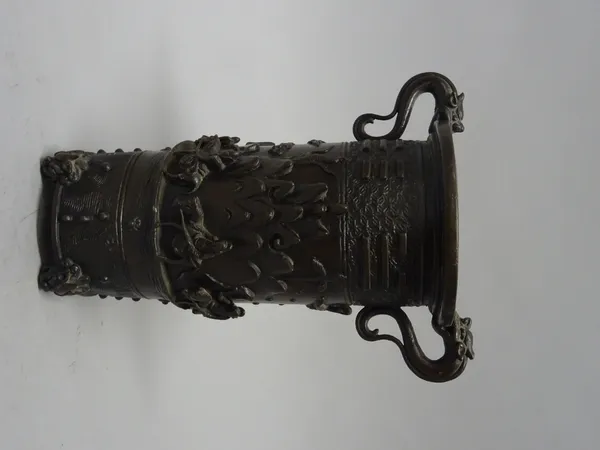 A Chinese Yuan style bronze two-handled vase, Ming dynasty, of cylindrical form with dragon handles, decorated in high relief with a pavilion and figu