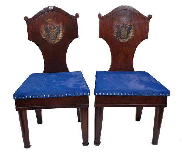 A pair of early 20th century mahogany shield back hall chairs, each with painted heraldic crest and blue upholstered seat, 55cm wide x 106cm high, (2)