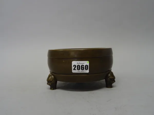 A Chinese bronze tripod censer, 18th century, of ribbed drum form raised on three mask supports, cast mark in relief within recessed rectangle ,8.5cm.