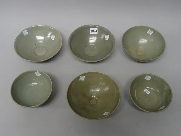 A group of Korean celadon bowls, Goryeo dynasty and later, comprising; two similar bowls with notched rims, two bowls with incised lotus lappets to th