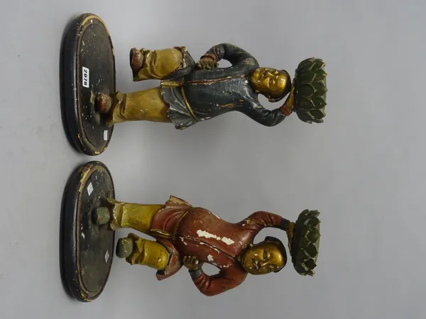 A pair of Chinese painted and gilt wooden figures of the Hehe Erxian twins, 19th century, each boy with one leg raised and holding aloft a lotus sconc