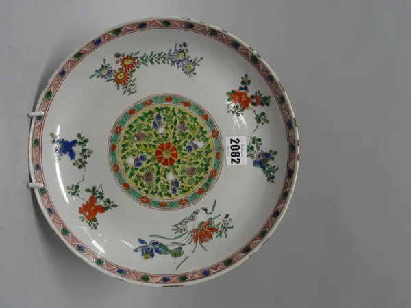 A Chinese famille-verte plate, Kangxi, painted in the centre with a foliate medallion, against a ground scattered with flower sprays, 27.5cm. diameter