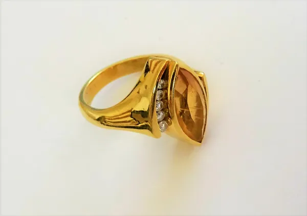 An 18ct gold, citrine and diamond ring, mounted with the marquise shaped citrine between two rows of five circular cut diamonds, in a twist design, ri