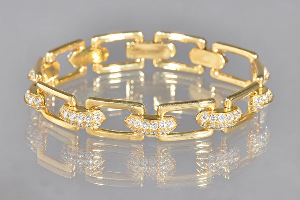 A gold and diamond set bracelet, designed as a series of diamond set curved links, mounted with two rows of circular cut diamonds, alternating with pl