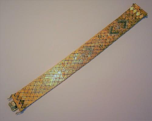 A two colour gold wide bracelet, in a quatrefoil shaped link design having a textured finish, on a snap clasp, detailed 750, with foldover safety catc