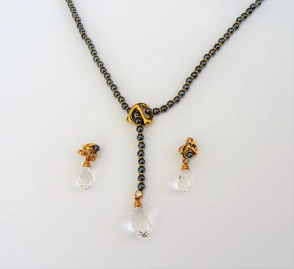 A haematite bead, diamond set and rock crystal necklace, the single row necklace of haematite beads, with a diamond topped, faceted rock crystal drop