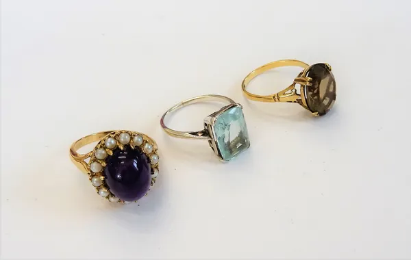 An aquamarine single stone ring, mounted with a mixed cut aquamarine, a 9ct gold ring, claw set with an oval cut smoky quartz and a gold ring, mounted