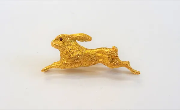 A 14ct gold brooch, designed as a running hare, with cabochon ruby set .eyes, import mark London possibly 1972, gross weight 11.3 gms.