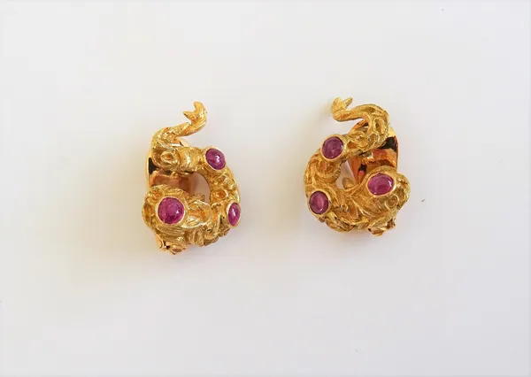 A pair of gold and cabochon ruby earclips, each in a cast serpentine design, having a rustic finish, mounted with three cabochon rubies, detailed K 18