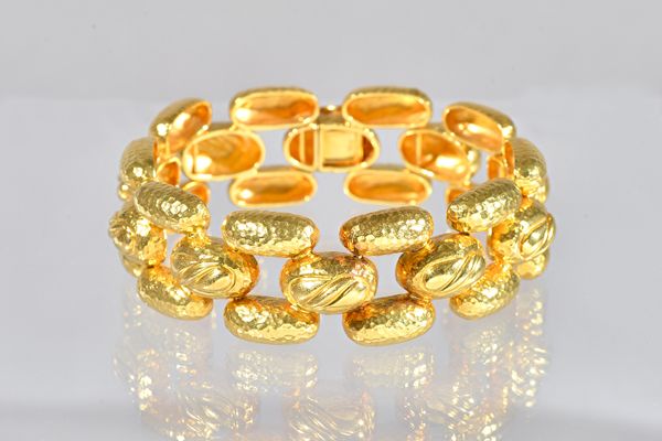 A gold bracelet, in a three row domed link design, with a partly martele finish, on a snap clasp, detailed 750, length 17.5cm, weight 54.2 gms.