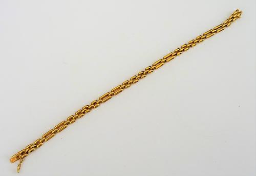 A gold bracelet, in a bar and oval link design, on a snap clasp, detailed 750, length 18.5cm, weight 12.5 gms.