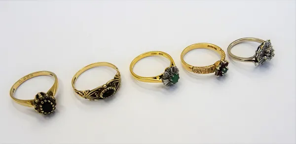 A diamond set cluster ring mounted with circular cut diamonds, between split shoulders, an 18ct gold ring, claw set with a circular cut emerald in a s