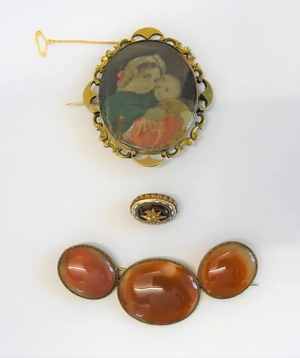 A Victorian shaped oval brooch, glazed with a portrait miniature of a woman with a child to the centre, within a scroll pierced surround, fitted with