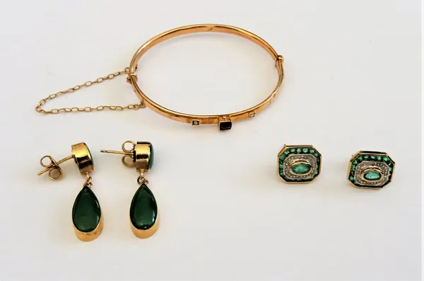 A pair of 9ct gold, emerald and diamond earstuds, each in a cut cornered rectangular design, mounted with the principal oval cut emerald to the centre