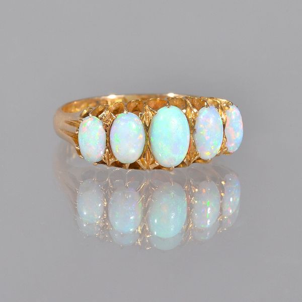 An 18ct gold and opal set five stone ring, mounted with a row of oval opals graduating in size to the centre stone, Chester probably 1910, ring size R