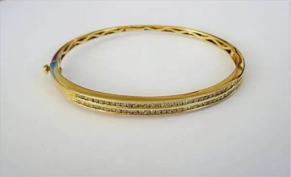 A gold and diamond set oval hinged bangle, mounted with two rows of small circular cut diamonds, on a snap clasp, detailed 14 K, gross weight 12.4 gms