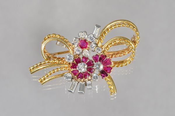 A gold ruby and diamond brooch, designed as a floral and ropetwist wirework spray, mounted with variously cut rubies and circular cut and baguette dia