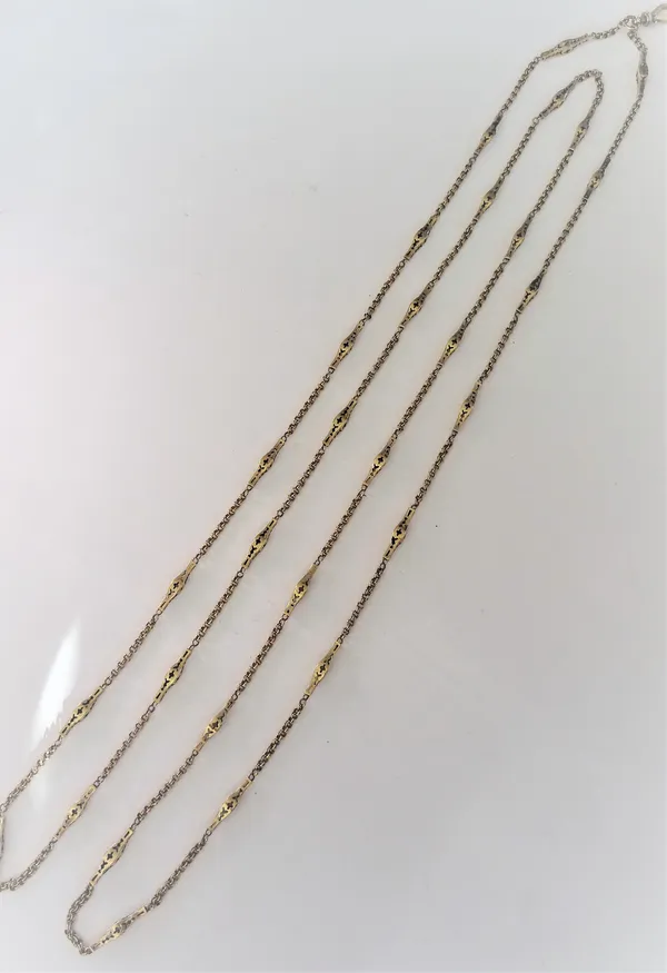 A gold long guard muff chain in a twin circular and pierced bar link design, the front fitted with a swivel clasp, length 136cm, weight 21.7 gms.