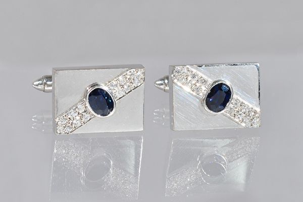 A pair of white gold, sapphire and diamond rectangular cufflinks, each collet set with an oval cut sapphire to the centre, between diamond set sides,