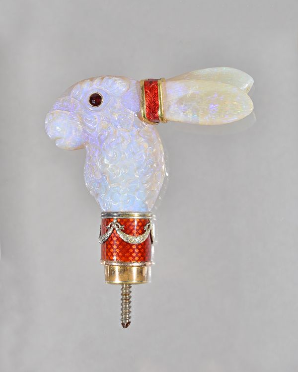 A carved opal and red enamelled parasol handle, designed as the head of a hare, with red gem set eyes and gilt mounts, having red enamelled decoration