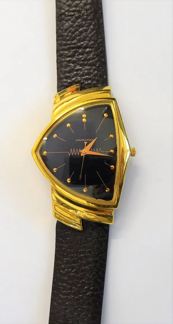 A Hamilton gilt metal fronted and metal backed quartz wristwatch, the case of curved triangular form, in the Art Deco taste, the signed black dial wit