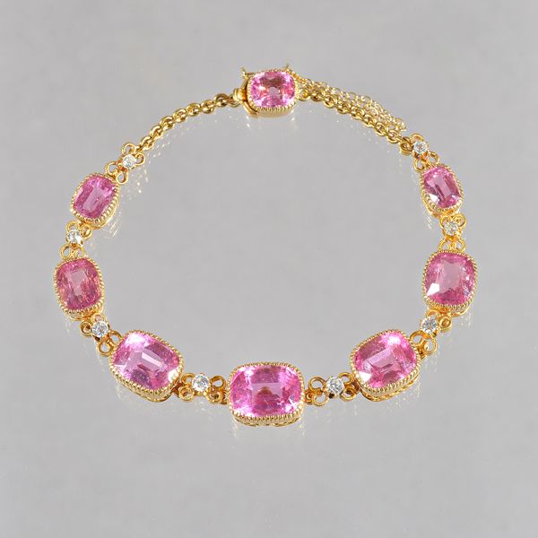 A gold, pink tourmaline and diamond bracelet, mounted with seven graduated cushion shaped pink tourmalines alternating with eight circular cut diamond