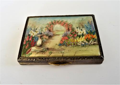 A lady's silver gilt rectangular powder compact, matt gilt within fitted with a mirror to the lid, the top fitted with a needle point panel, depicting