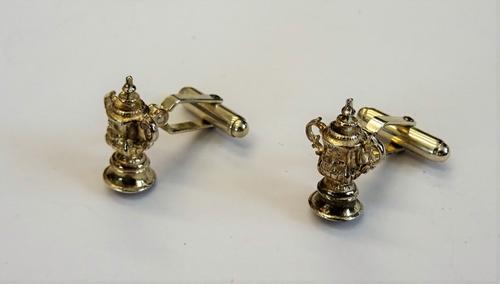 A pair of silver cufflinks, the fronts designed as The FA Cup and with folding sprung bar fittings at the backs, combined gross weight 11 gms, by Mapp