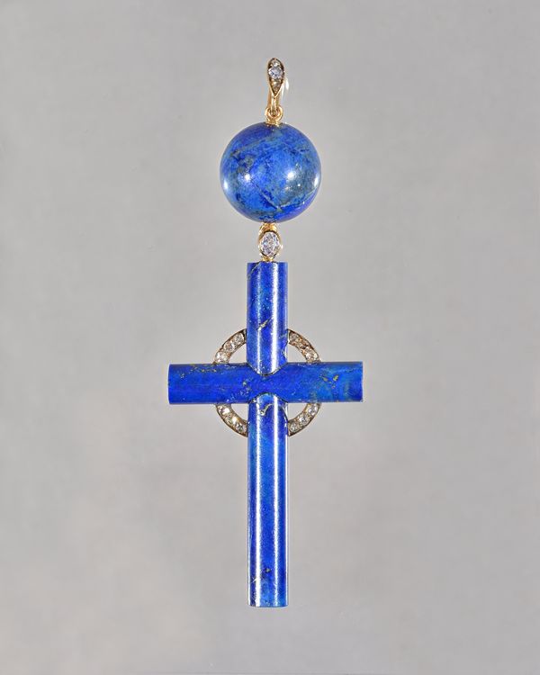 A lapis lazuli and diamond set pendant cross, the cross of cylindrical form with a central diamond set circular motif, surmounted by the principal ova