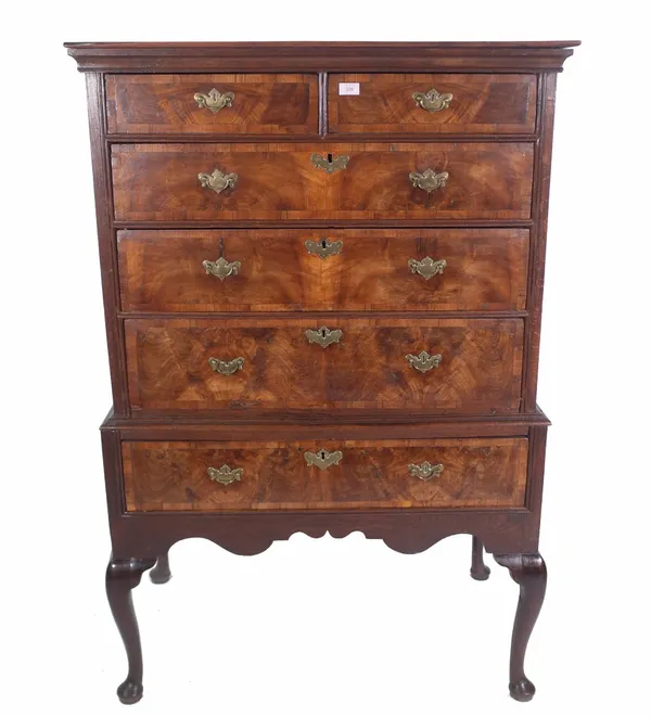 An early 18th century and later walnut crossbanded chest on stand with two short and three long drawers, above a single drawer base and cabriole suppo