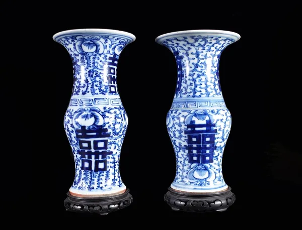 A pair of Chinese blue and white baluster vases, modern, painted with lotus flowers and characters, 37cm high with wooden stands. (4) Provenance; prop