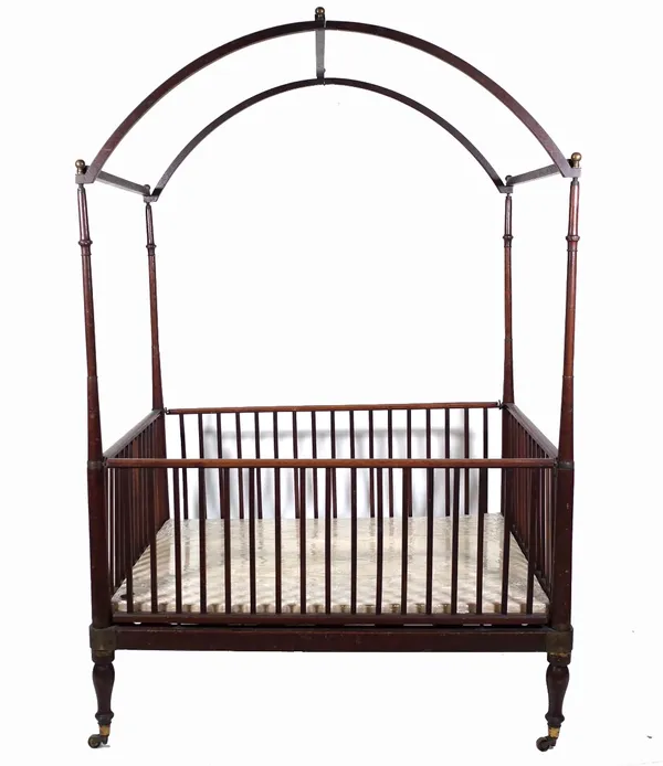 A 19th century campaign style mahogany arch top child's crib, 121cm wide x 90cm deep x 185cm high. Provenance; property from the late Sir David Tang T