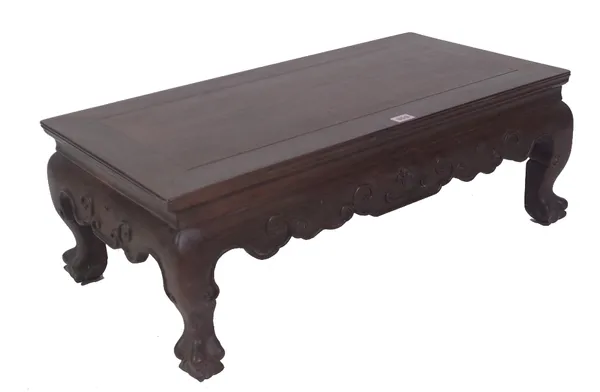 An early 20th century Chinese hardwood low table on claw feet, 76cm wide x 41cm deep x 28cm high. Provenance; property from the late Sir David Tang Th