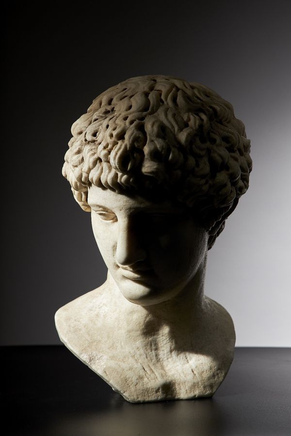 After the Antique; a carved white marble portrait bust of a man, drill carved hair, recessed eyeballs, unsigned, 42cms high.  Provenance; property fro
