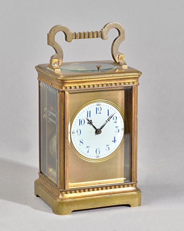 A FRENCH BRASS PETITE SONNERIE CARRIAGE CLOCKCirca 1900In a stylised Corniche case with shaped handle, the engine-turned gilt dial surround enclosing