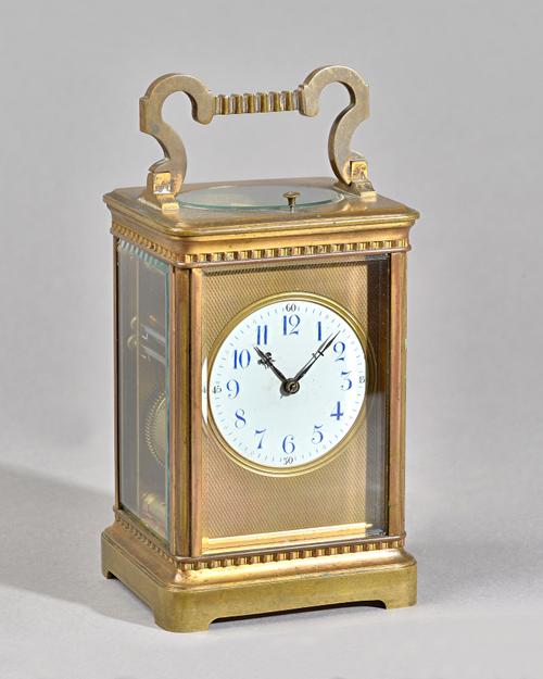 A FRENCH BRASS PETITE SONNERIE CARRIAGE CLOCKCirca 1900In a stylised Corniche case with shaped handle, the engine-turned gilt dial surround enclosing