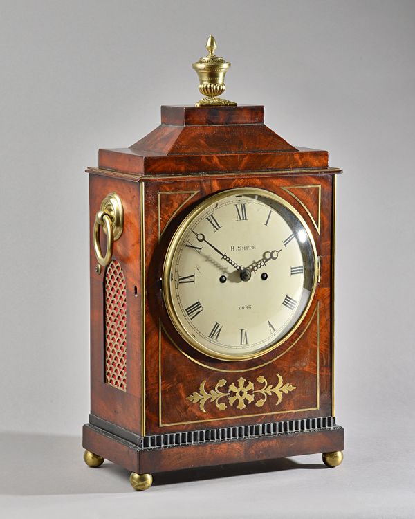 A REGENCY BRASS-INLAID MAHOGANY BRACKET CLOCKBy Horatio Smith, York, circa 1825The chamfer-top case surmounted by a vase pomander finial, the front wi