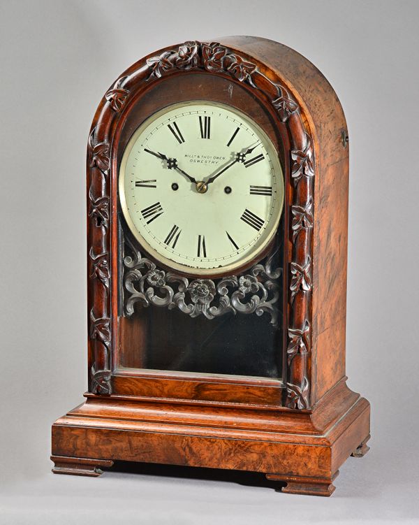 A VICTORIAN WALNUT QUARTER-STRIKING LIBRARY CLOCKSigned William & Thomas Owen, Oswestry, circa 1870The arched-top case with foliate carved glazed door