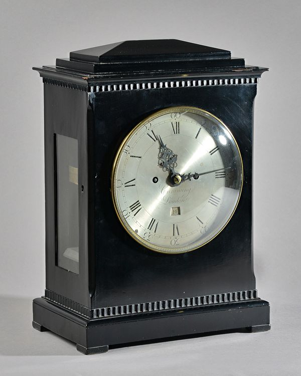 A REGENCY EBONISED BRACKET CLOCKBy Cumming, LondonThe case with a chamfered top above a stepped pediment, with brass bezel and convex glass, between c