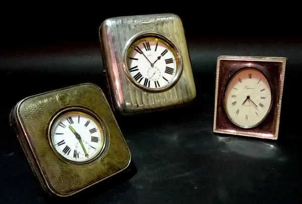 A silver mounted easel watch case, containing a base metal 8 day Goliath watch, hallmarks rubbed, together with a small example and a silver mounted b