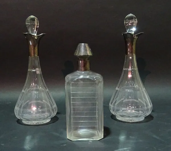 A pair of late Victorian silver mounted faceted glass decanters, London 1898 and another silver mounted decanter, (3).  Provenance; property from the